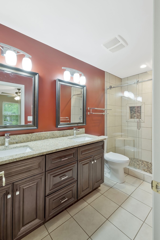 bathroom with tile flooring, a shower with shower door, dual bowl vanity, ceiling fan, and toilet