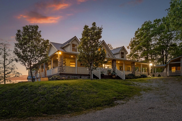 log home with metal roof, a porch, and a front yard