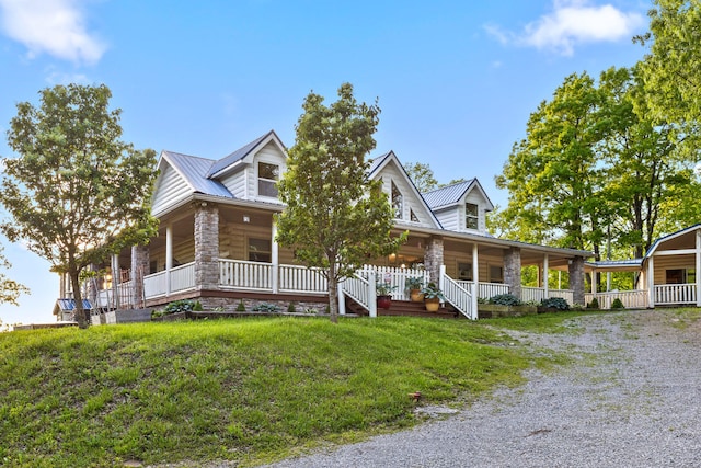 view of front of house with covered porch, metal roof, and driveway