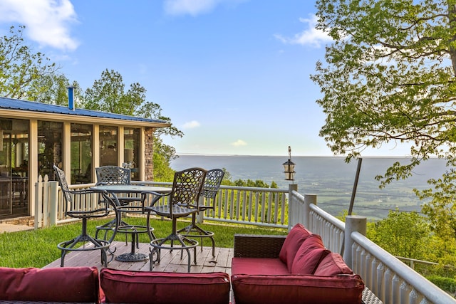 wooden terrace with a water view and a sunroom