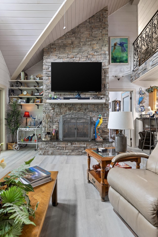 living room with high vaulted ceiling, a stone fireplace, wood finished floors, and wood ceiling