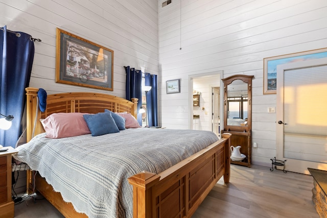 bedroom featuring wooden walls and wood finished floors