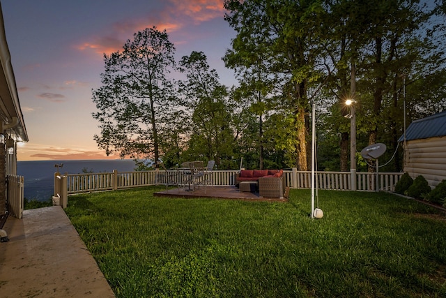 yard at dusk with a fenced backyard, a patio, and outdoor lounge area