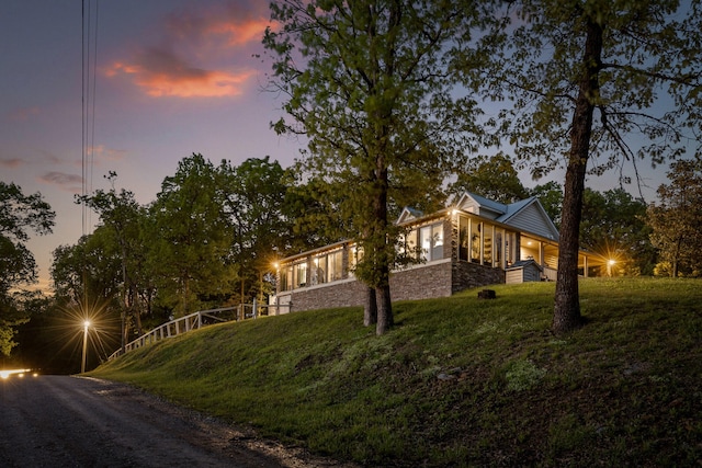 view of property exterior with stone siding and a lawn