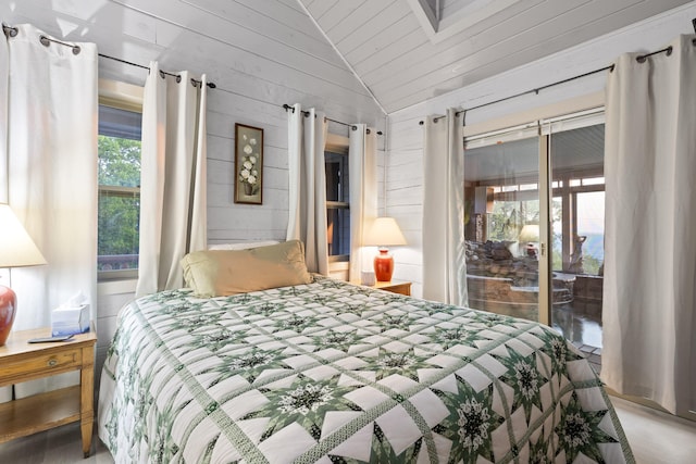 bedroom with lofted ceiling, access to outside, and wooden walls