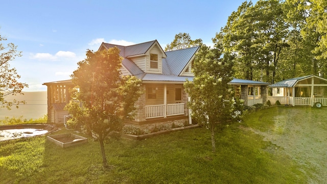 view of home's exterior with a garage, a garden, metal roof, and a yard