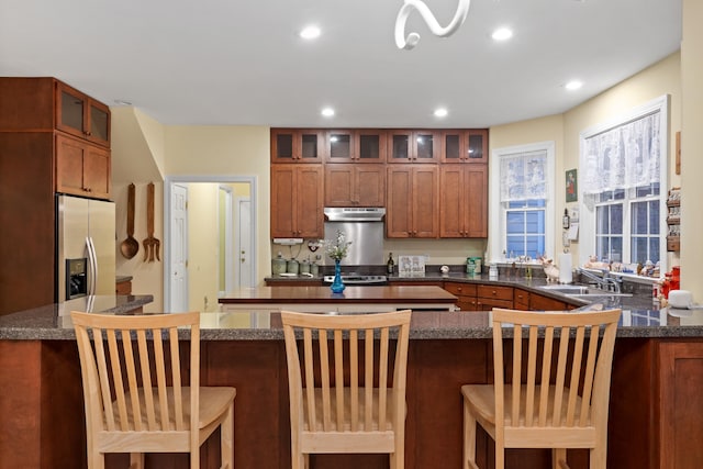 kitchen featuring sink, appliances with stainless steel finishes, a breakfast bar, and kitchen peninsula