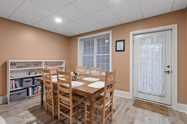 dining room featuring light hardwood / wood-style floors, a wealth of natural light, and a paneled ceiling