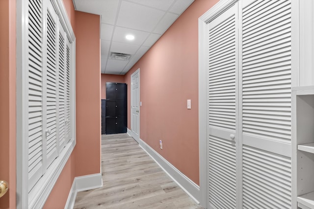 corridor featuring a drop ceiling and light hardwood / wood-style flooring