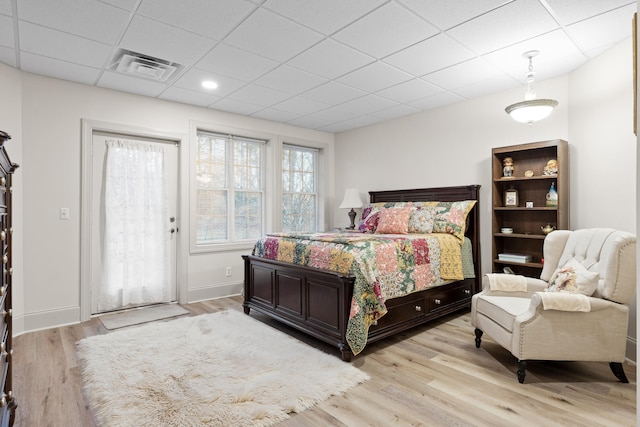 bedroom featuring a paneled ceiling and light wood-type flooring