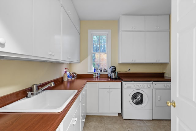 clothes washing area featuring sink, independent washer and dryer, cabinets, and light tile patterned floors