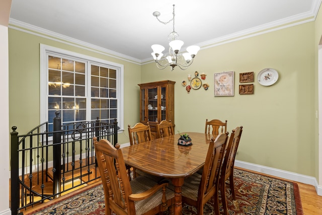 dining area featuring an inviting chandelier, hardwood / wood-style floors, and crown molding