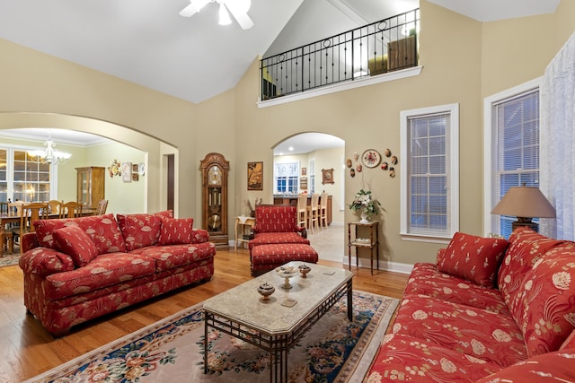 living room with a notable chandelier, high vaulted ceiling, and hardwood / wood-style floors