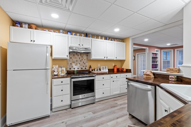 kitchen with white cabinetry, butcher block countertops, appliances with stainless steel finishes, and light hardwood / wood-style flooring