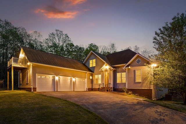 view of front of house with central AC, a lawn, a balcony, and a garage