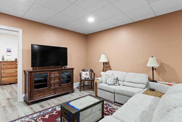 living room with light hardwood / wood-style floors and a drop ceiling