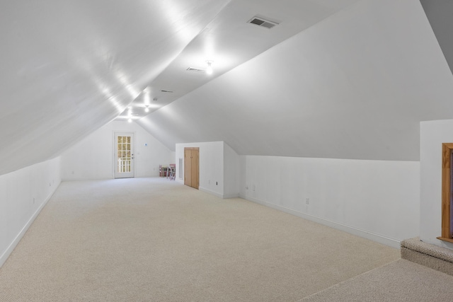 bonus room with light carpet and lofted ceiling