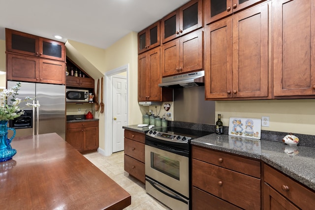 kitchen featuring dark stone countertops, stainless steel appliances, and light tile patterned floors