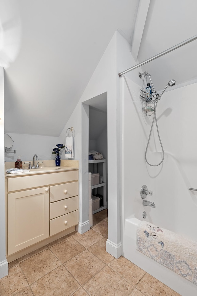 bathroom featuring vanity, lofted ceiling with beams, and shower / bathing tub combination