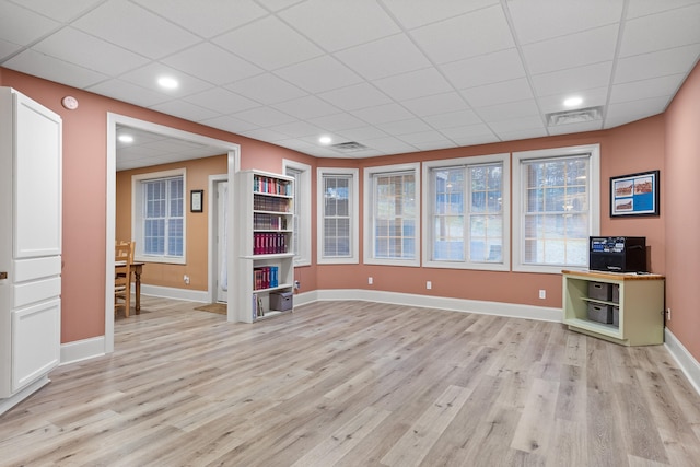 unfurnished office with light hardwood / wood-style flooring and a paneled ceiling