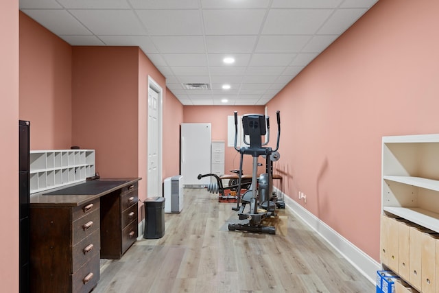 exercise area featuring light hardwood / wood-style flooring and a paneled ceiling