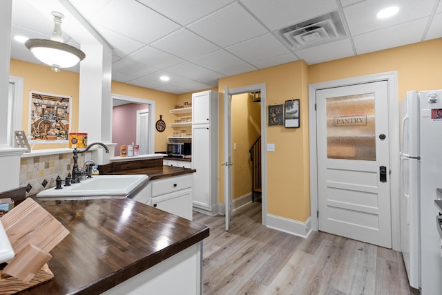 kitchen with sink, light wood-type flooring, white cabinetry, a paneled ceiling, and white refrigerator