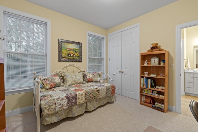 carpeted bedroom with a closet and ensuite bathroom