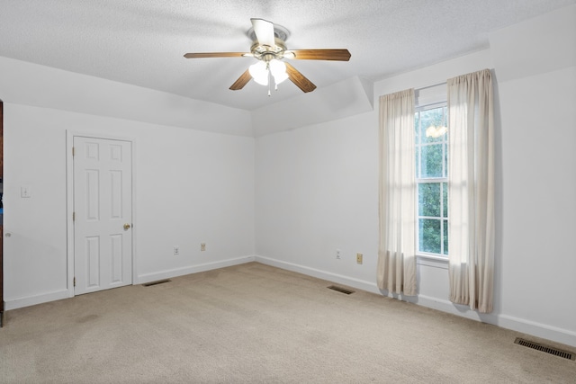 carpeted spare room featuring ceiling fan and a textured ceiling