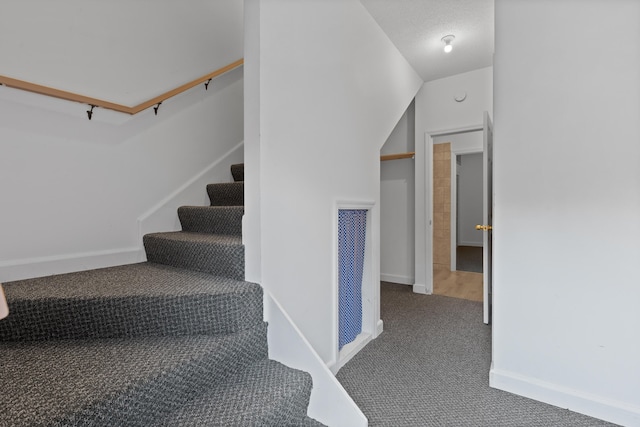 stairs featuring carpet and vaulted ceiling