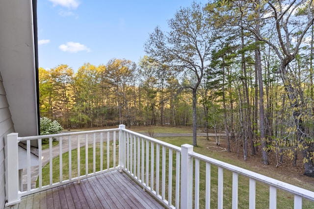 wooden deck featuring a lawn