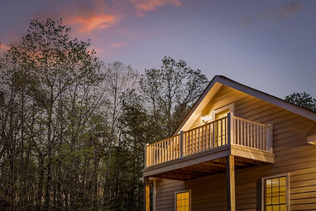 property exterior at dusk featuring a balcony