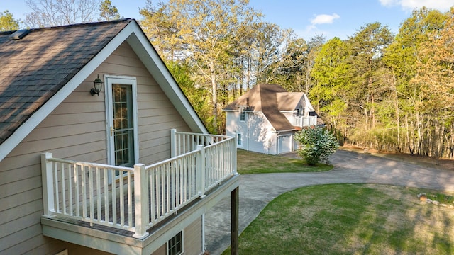 view of side of property featuring a deck, a lawn, an outdoor structure, and a garage