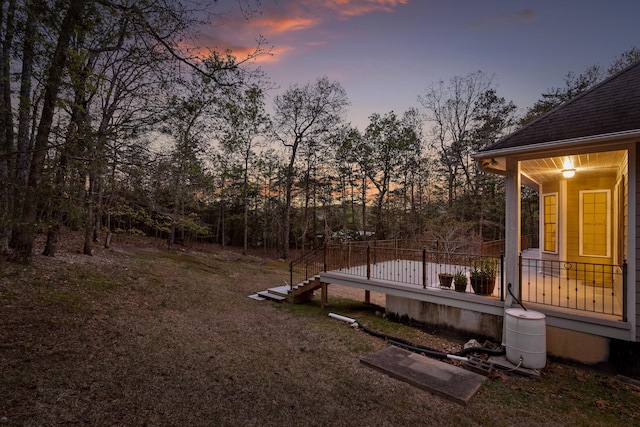 yard at dusk featuring a deck