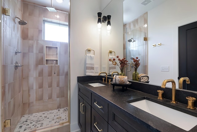 bathroom with double vanity and tiled shower