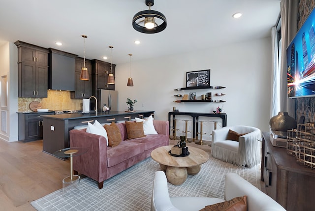 living room with sink and light hardwood / wood-style floors