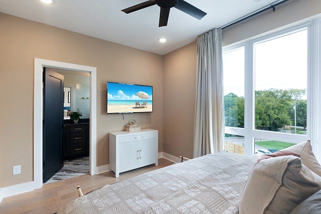 bedroom featuring ceiling fan, multiple windows, and light hardwood / wood-style floors