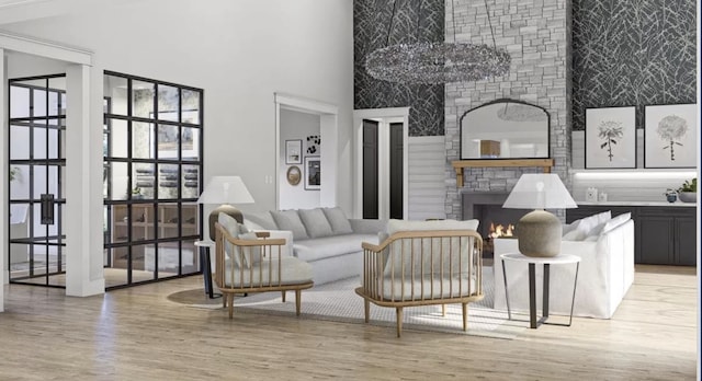 living room featuring a high ceiling, a fireplace, and light hardwood / wood-style flooring