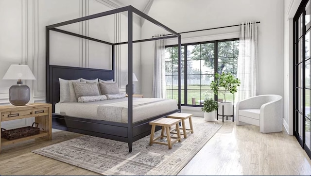 bedroom with a high ceiling and light hardwood / wood-style floors