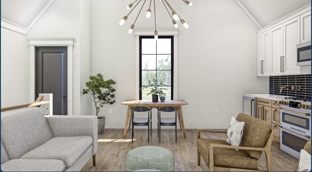 living room with a notable chandelier, vaulted ceiling, and hardwood / wood-style floors