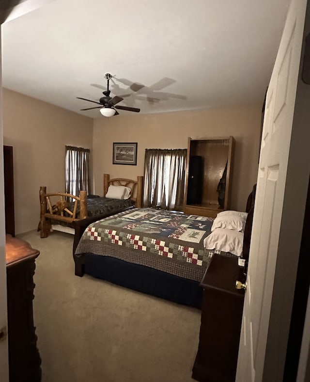 bedroom featuring ceiling fan and carpet