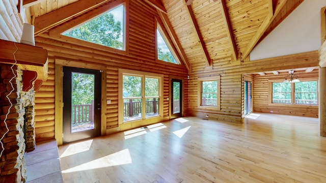 unfurnished living room featuring high vaulted ceiling, wooden ceiling, hardwood / wood-style floors, and rustic walls