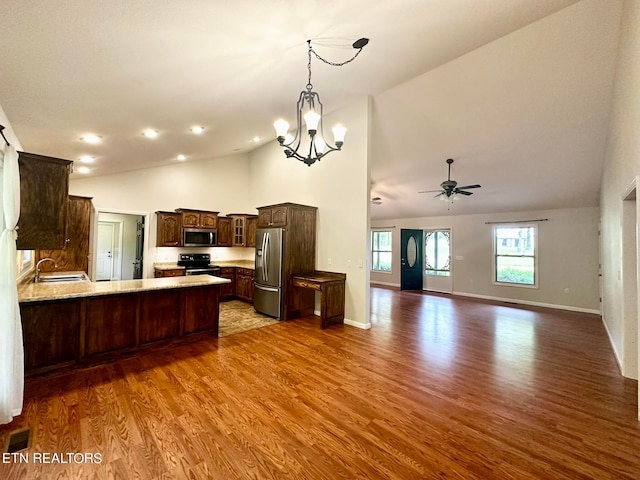 kitchen with ceiling fan with notable chandelier, appliances with stainless steel finishes, dark brown cabinets, light wood-type flooring, and sink