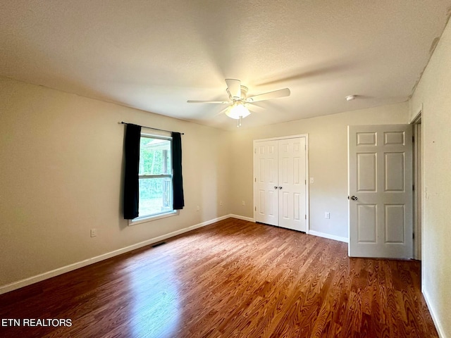 unfurnished bedroom featuring ceiling fan, a textured ceiling, and hardwood / wood-style flooring