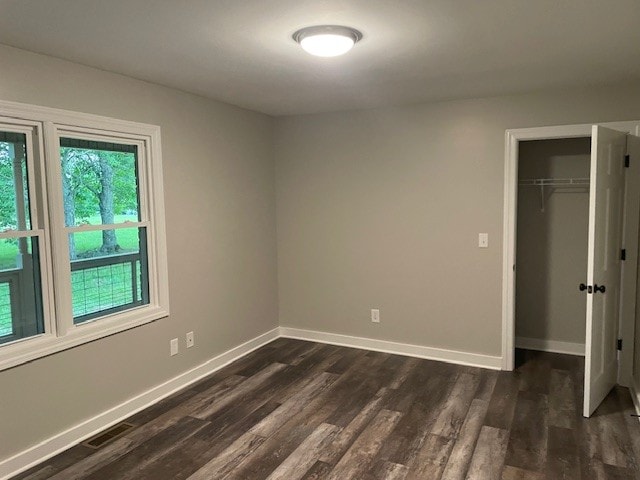 unfurnished bedroom featuring a closet and dark hardwood / wood-style flooring