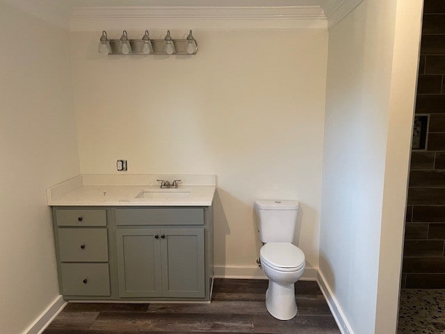 bathroom featuring toilet, crown molding, wood-type flooring, and vanity