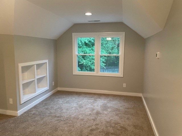 bonus room with carpet flooring, lofted ceiling, and built in features