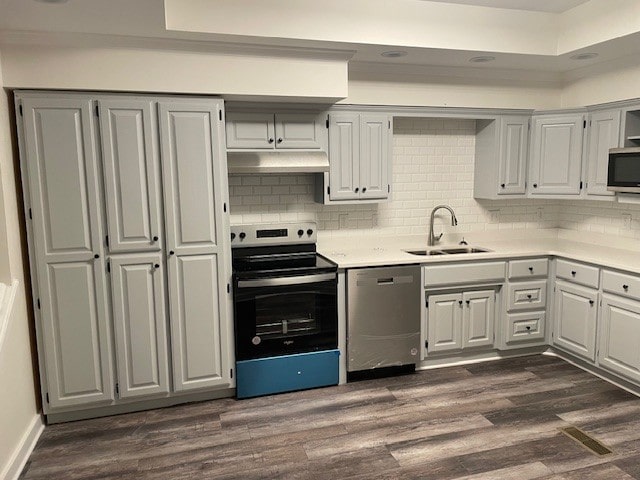 kitchen featuring dark wood-type flooring, appliances with stainless steel finishes, tasteful backsplash, and sink