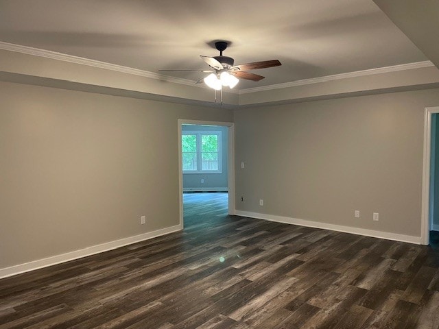 unfurnished room featuring ceiling fan, dark wood-type flooring, and crown molding