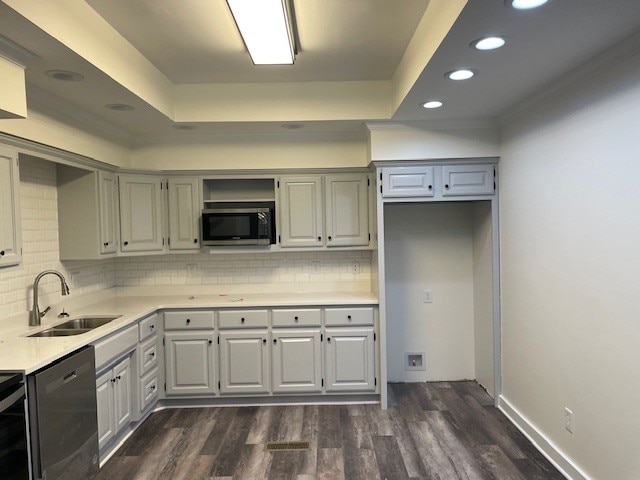 kitchen with tasteful backsplash, dark wood-type flooring, sink, and black dishwasher