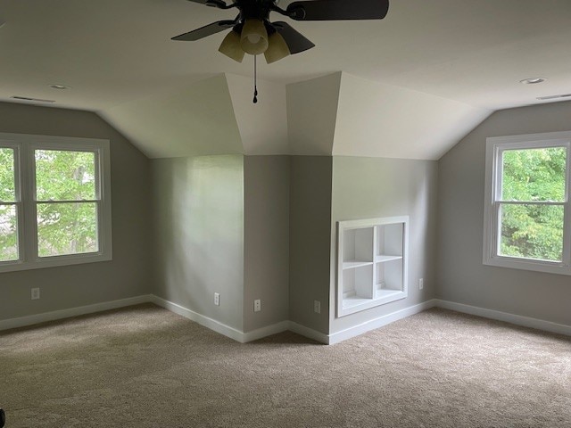 bonus room featuring light carpet, ceiling fan, vaulted ceiling, and built in features